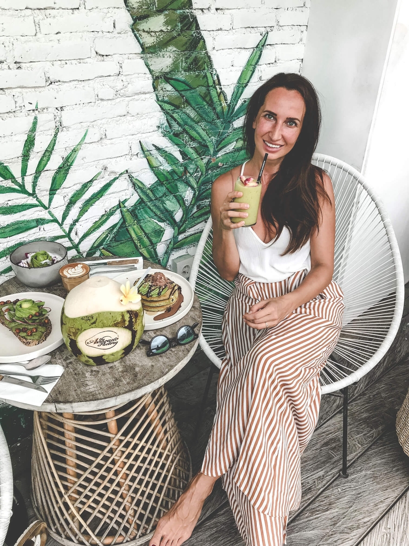 Dark Haired Woman sipping a smoothie at brunch